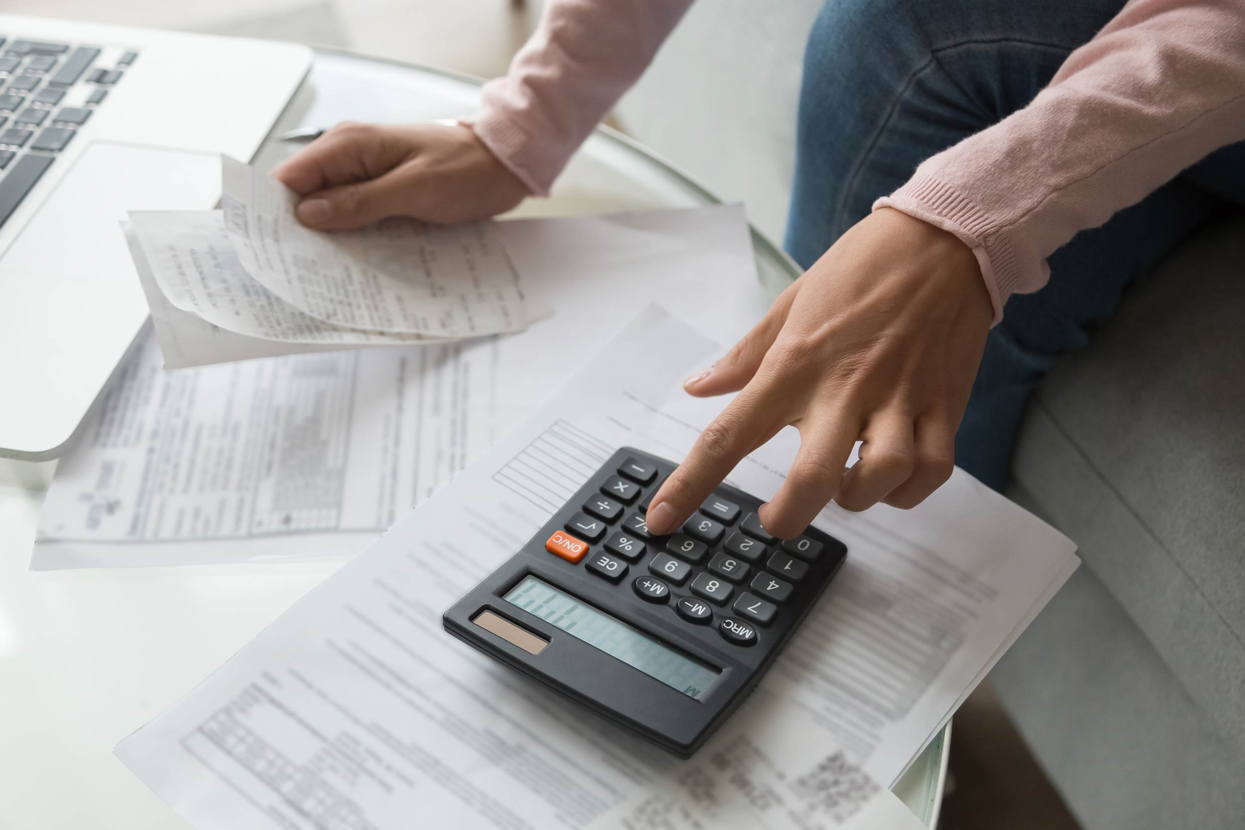 Bookkeeping at home with papers and calculator on table