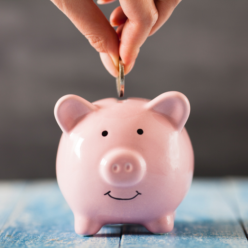 Piggy bank with coin being dropped into it