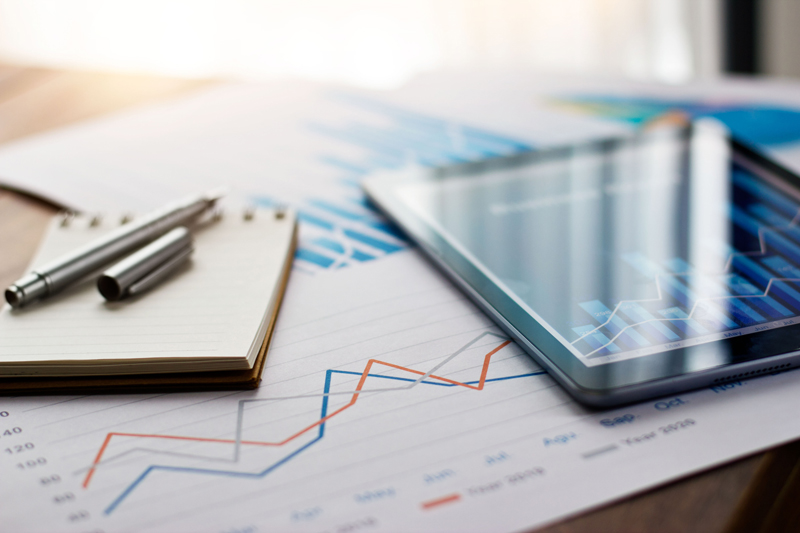 financial reports on table with pen, paper and tablet